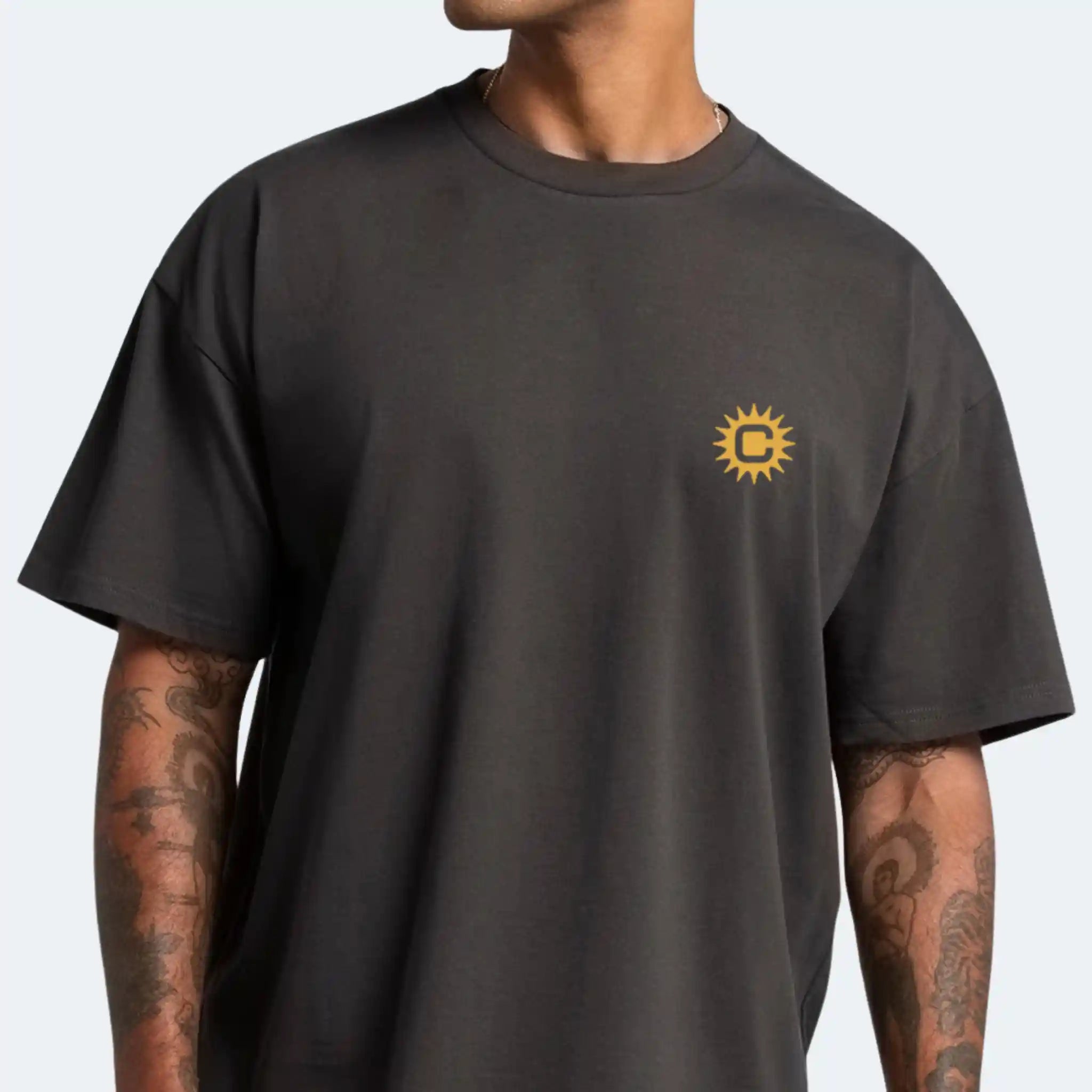 Person wearing a black t-shirt with a yellow Chroma logo on a plain background