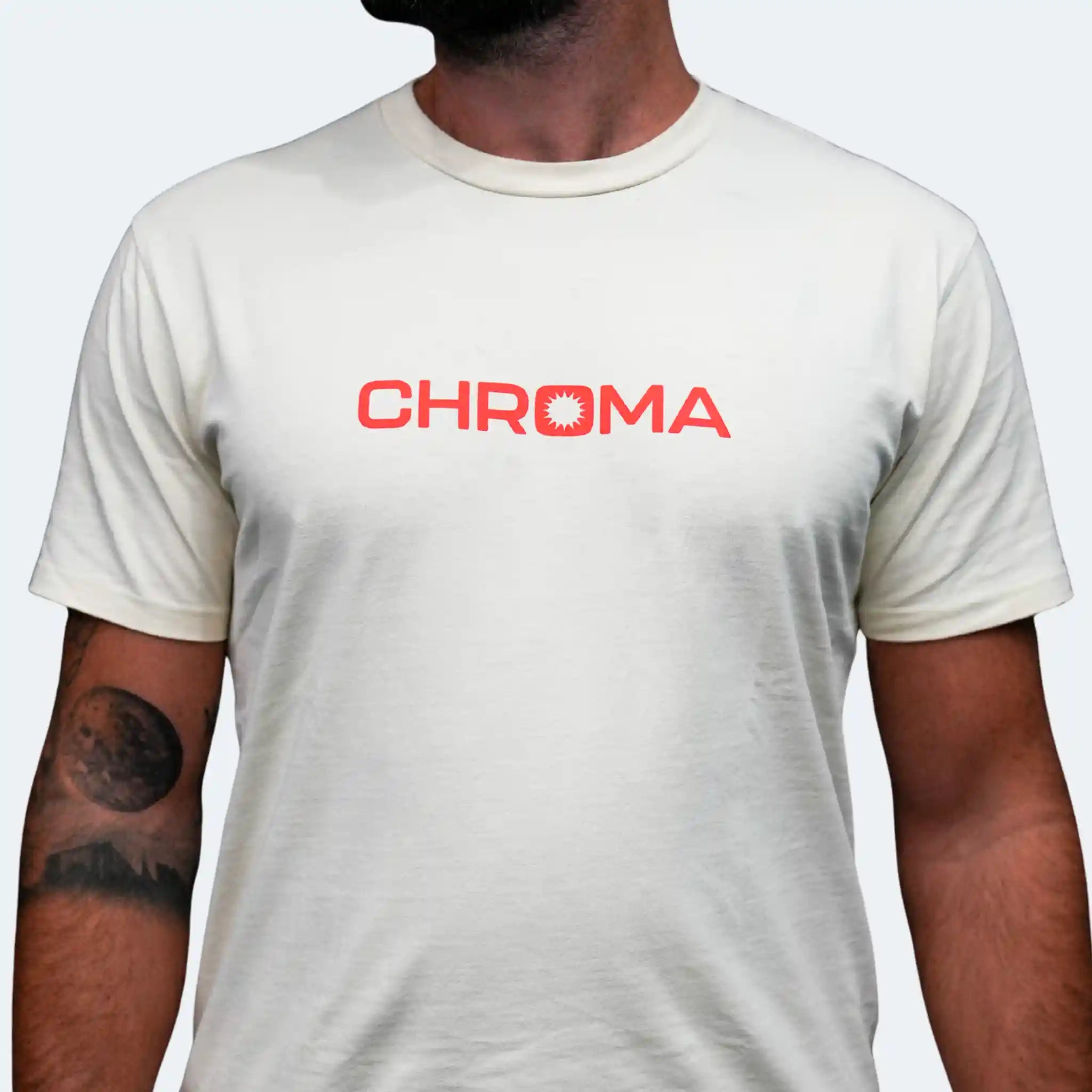 Person wearing a white t-shirt with 'CHROMA' logo on a plain background