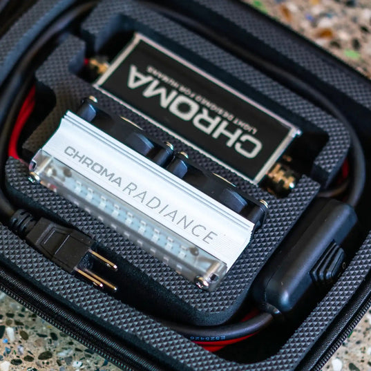 Chroma Radiance light therapy electronic device with visible branding inside a hard case on a textured surface