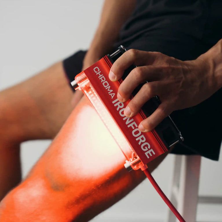Chroma Ironforge Light Therapy Device being used on upper leg to show targeted recovery method.