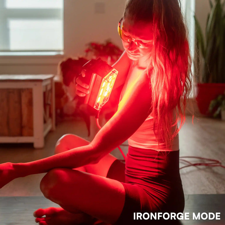 Woman using a Chroma trinity red light therapy device in a home setting with 'IRONFORCE MODE' text.