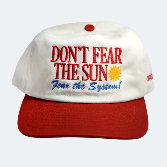 White cap with red brim and text 'Don't Fear the Sun, Fear the System!' on a white background